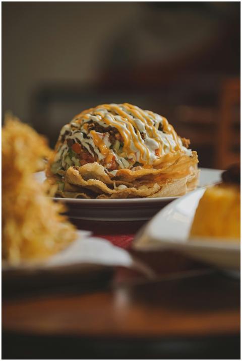 Close-up shot of loaded nachos with sauces and top