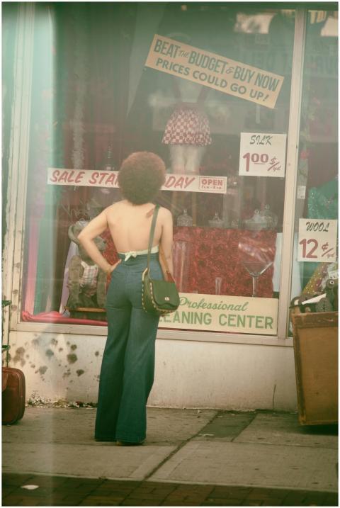 A woman in retro fashion standing outside a vintag