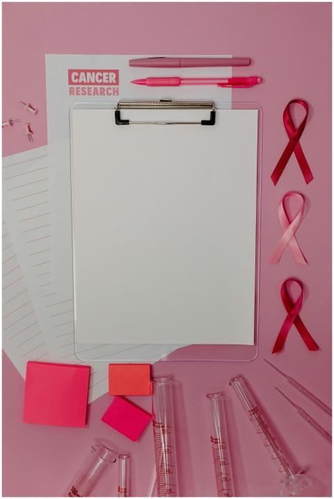 Clipboard with pink ribbons and cancer research pa