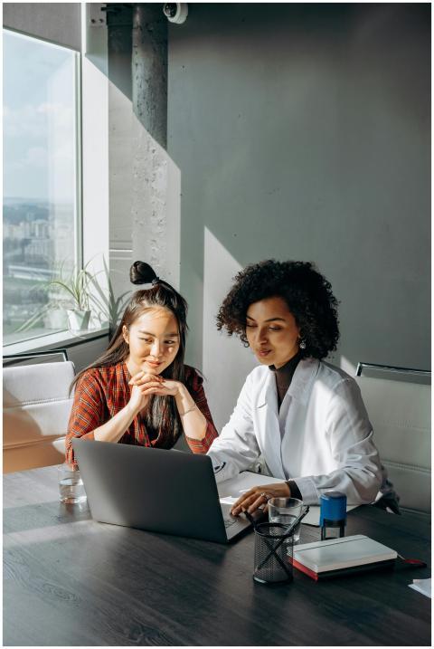 Two women collaborating on a laptop in a modern of