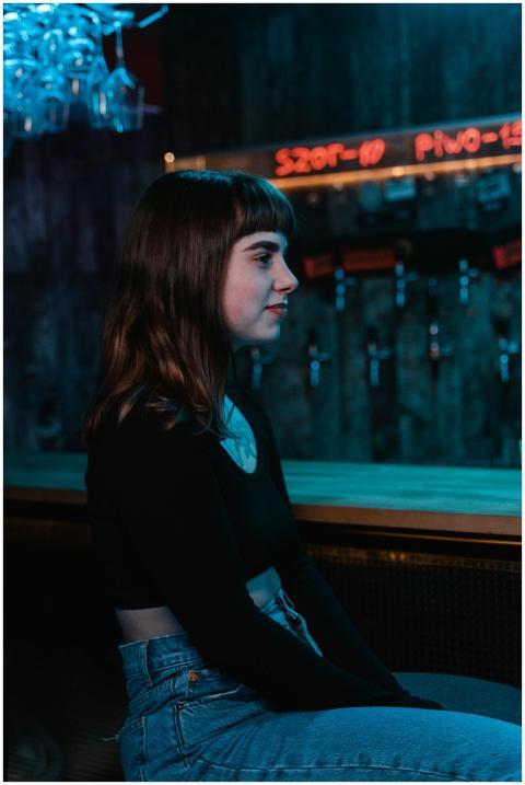 Profile view of a young woman sitting in a dimly l