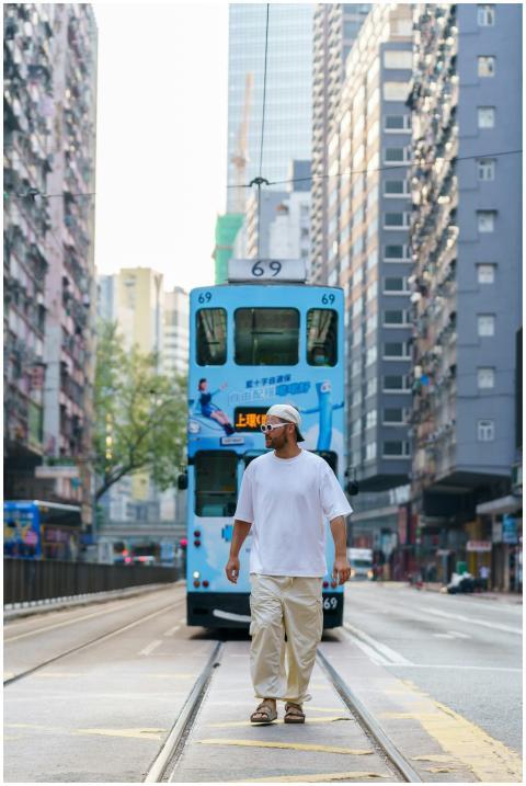 Casually dressed man crosses tram tracks in busy u