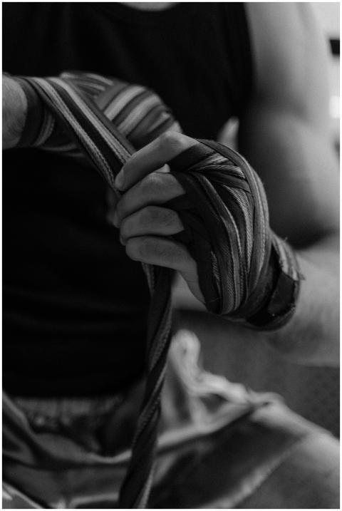Grayscale photo of an athlete wrapping hands, focu