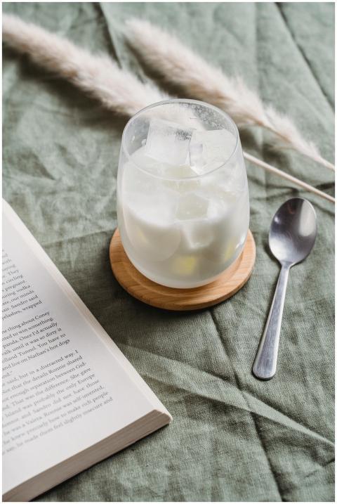 A cozy setup with a glass of iced milk, open book,