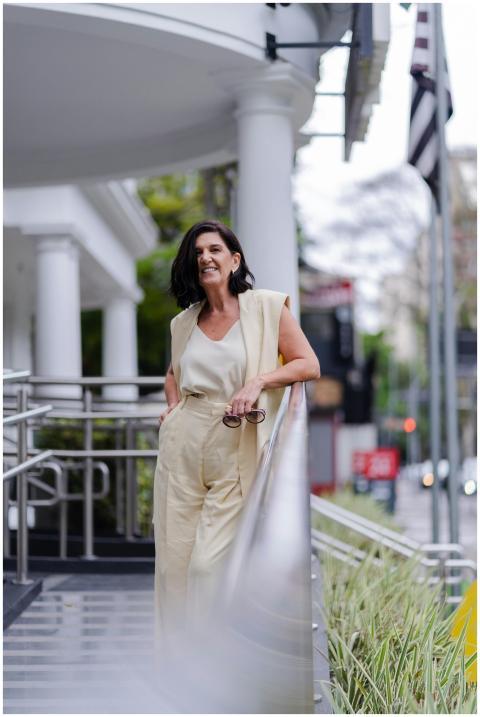 Adult woman in stylish outfit smiling outdoors in