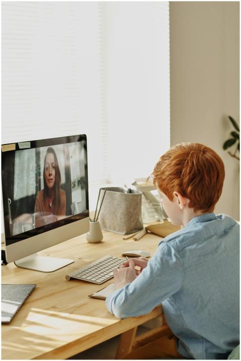 A young boy with red hair participates in an onlin