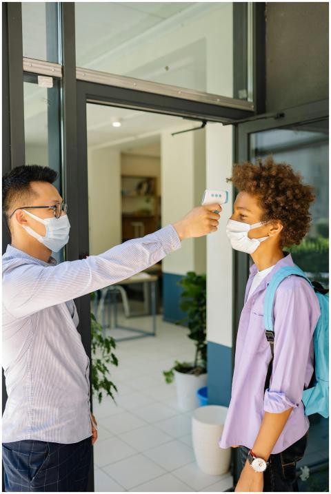 Student getting temperature checked at school entr