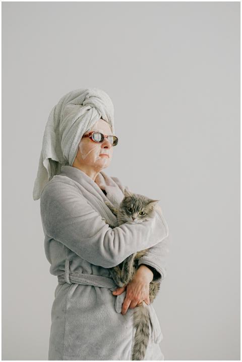 Woman in a bathrobe with a cat, representing relax