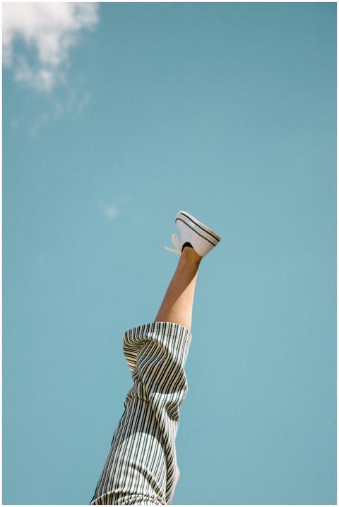 A single leg playfully sticks upward with striped