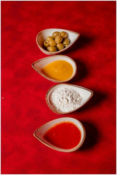 Four key pizza ingredients beautifully arranged on