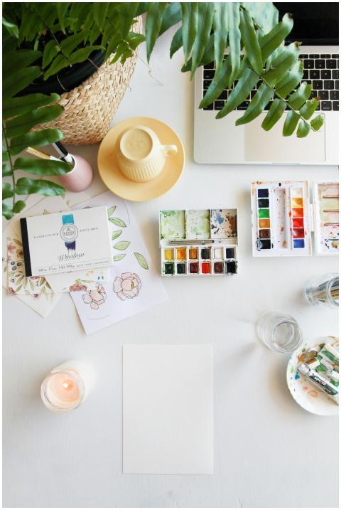 Flat lay of a creative workspace with watercolors,