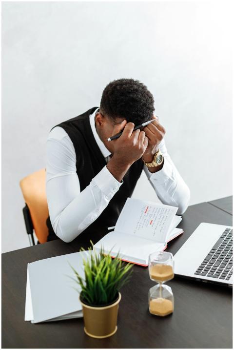 A businessman overwhelmed working indoors with a n