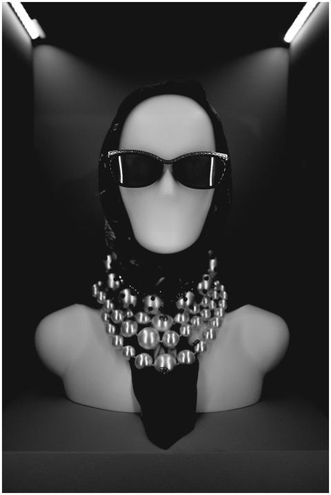 Stylish mannequin with sunglasses and pearl neckla