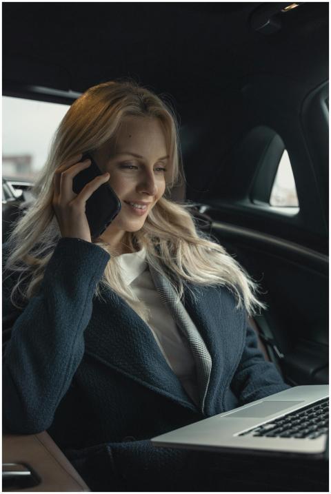 Professional woman in a car, talking on mobile pho