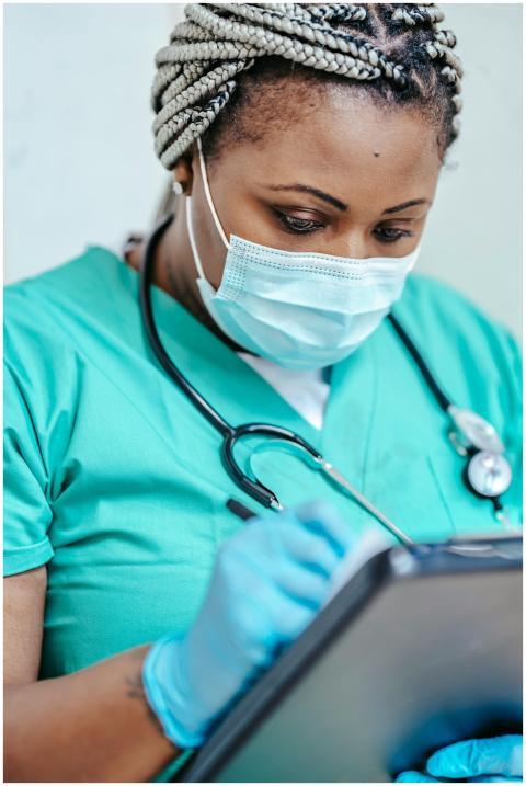 Nurse with mask and gloves reviewing documents on