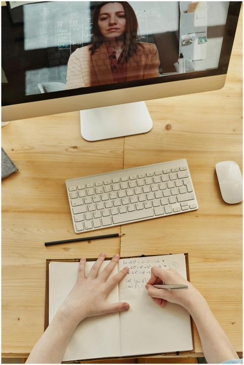 A student taking notes during an online learning s