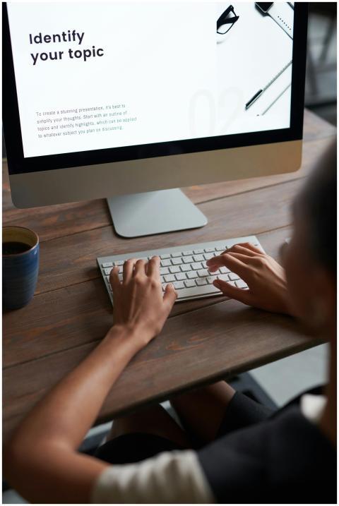 Person working on a digital project at a wooden de
