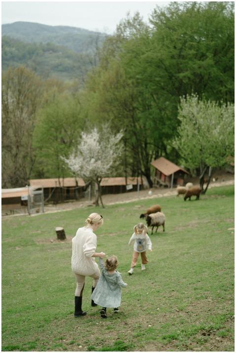 A family enjoys a stroll with children on a lush g