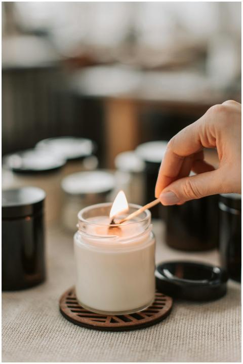 Close-up of a hand lighting a handmade candle with