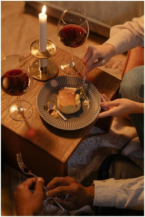 Intimate setting with cake, wine, and candlelight,