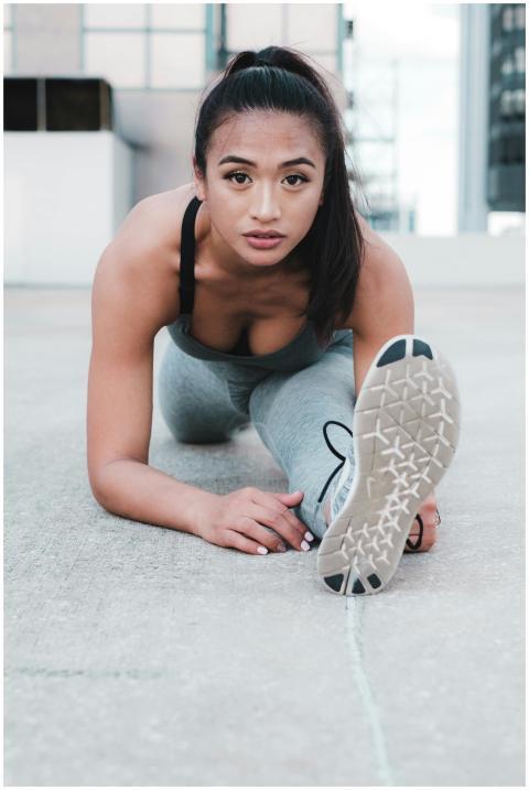 Asian woman in activewear stretching outdoors for