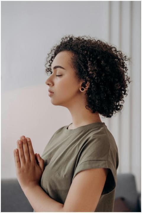 Profile of a young woman meditating indoors, embod