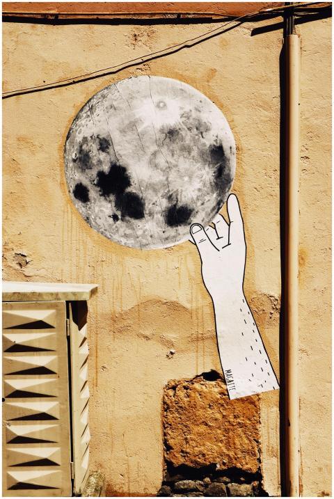 Street mural depicting a hand reaching towards a f