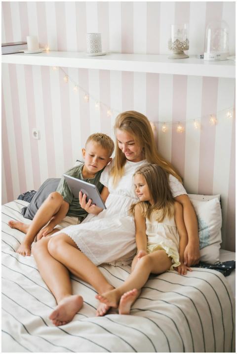 A mother reads with her children using a tablet on