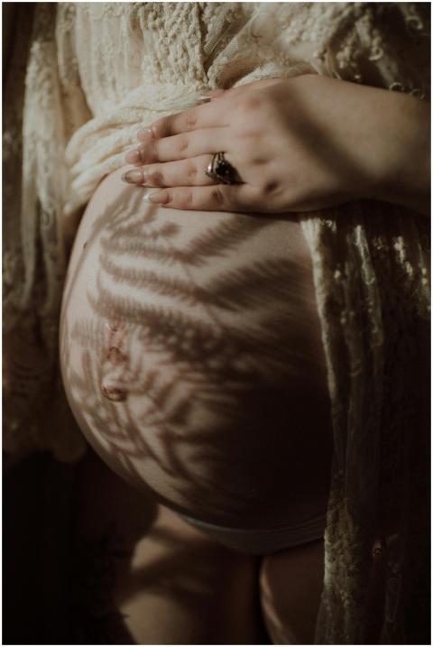 Close-up of a pregnant belly with shadows from lac