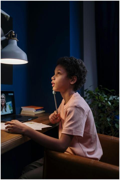A child focusing on an online lesson at home, unde