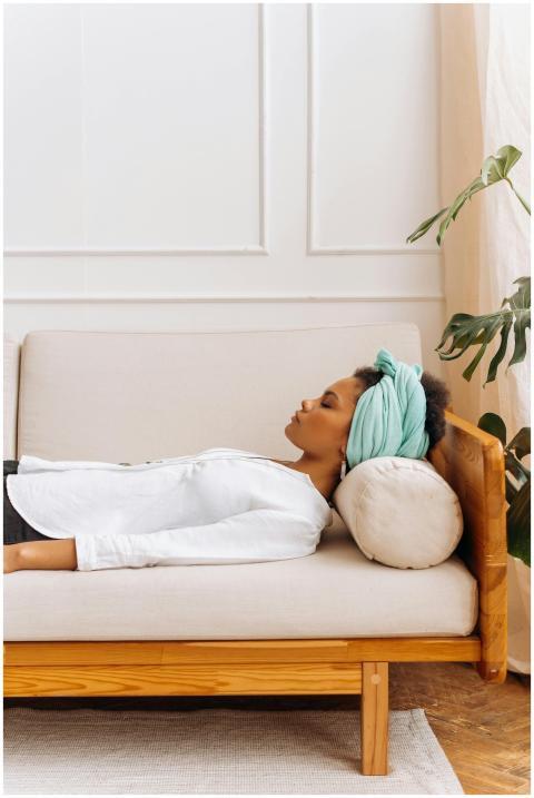 A woman peacefully resting on a sofa, showcasing a