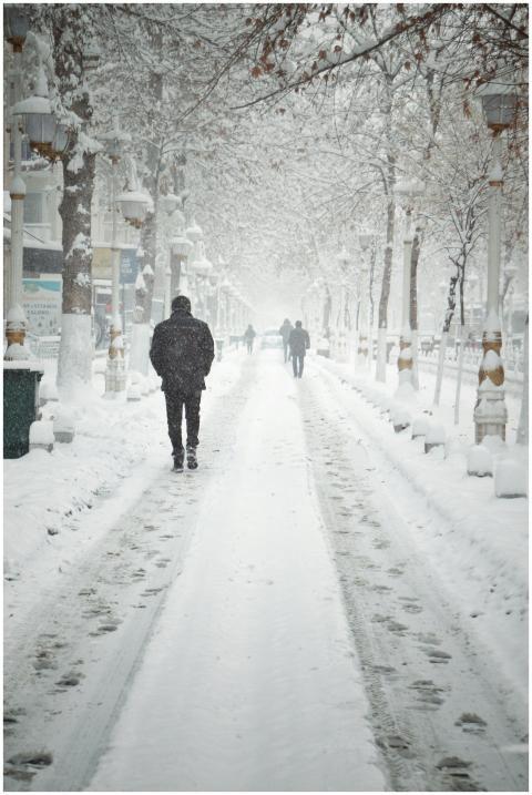 A serene winter scene with people walking on a sno
