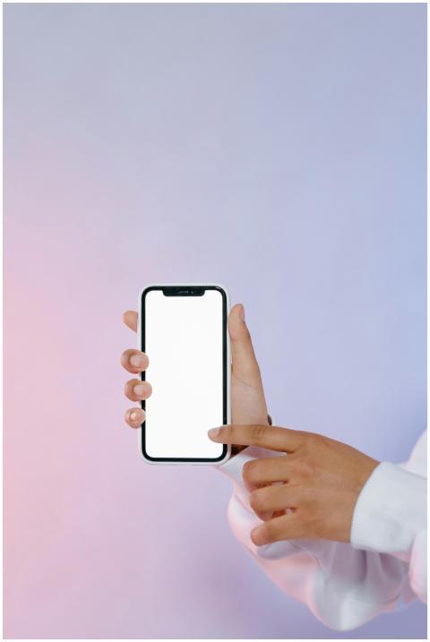A person holds a smartphone with a blank screen, p