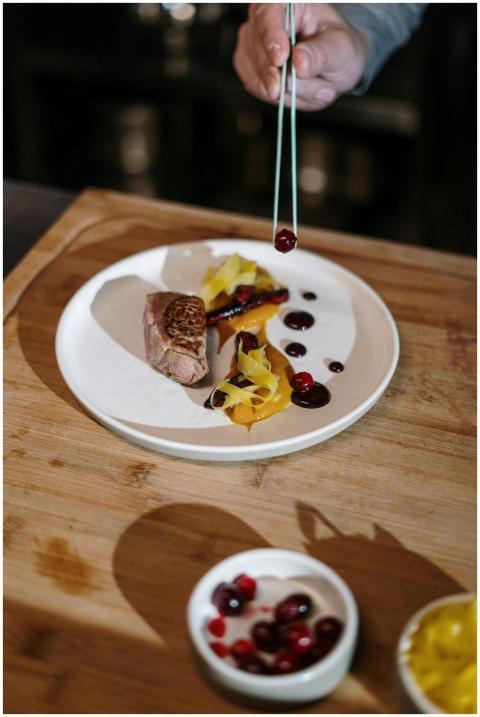 Close-up of a chef garnishing a gourmet steak and
