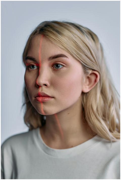 Blonde woman with red laser line on face, depictin