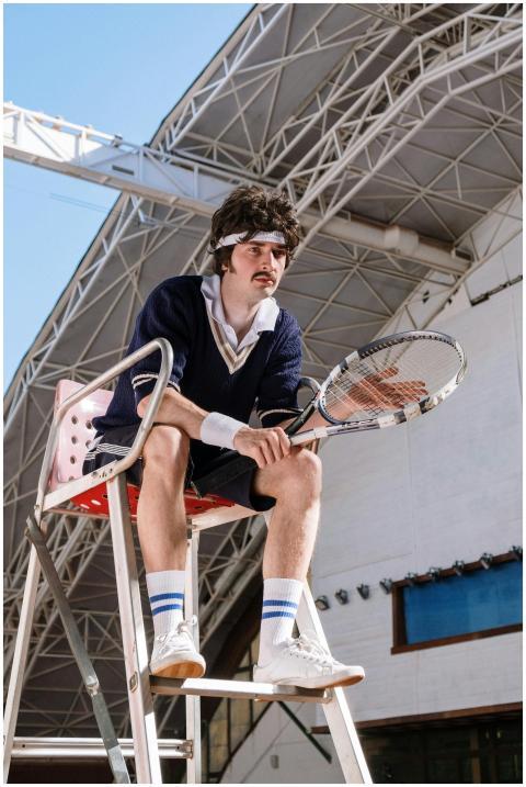 Vintage-style tennis player with racket sitting on