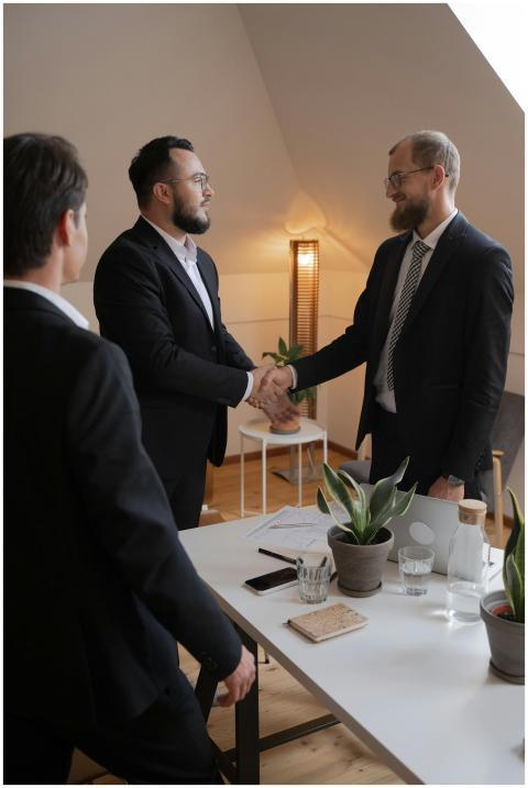 Businessmen in formal attire shaking hands during