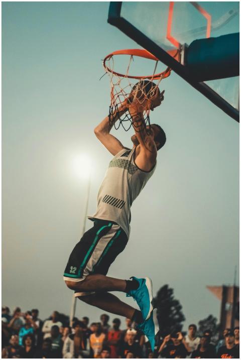Athlete performs a powerful dunk on an outdoor bas