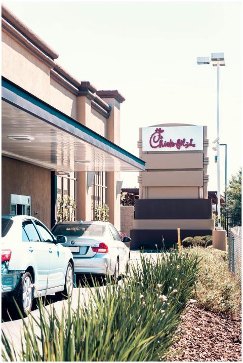 Vehicles in a drive-thru line outside a busy fast