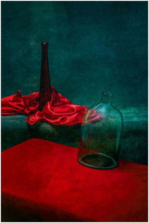 Artistic still life featuring red fabric and glass