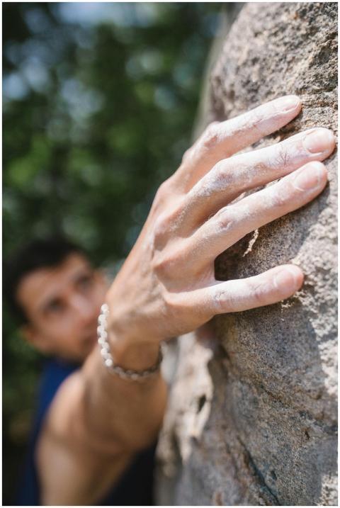 Close-up of a climber's hand grasping a rock face,