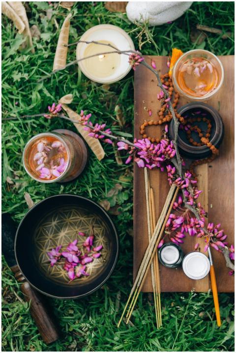 A serene outdoor setup featuring candles, incense,