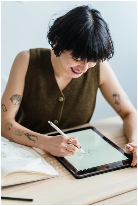 Young female artist drawing digitally with stylus,