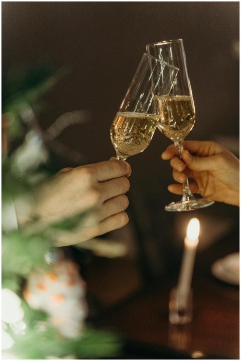 Two people toasting with champagne indoors, creati