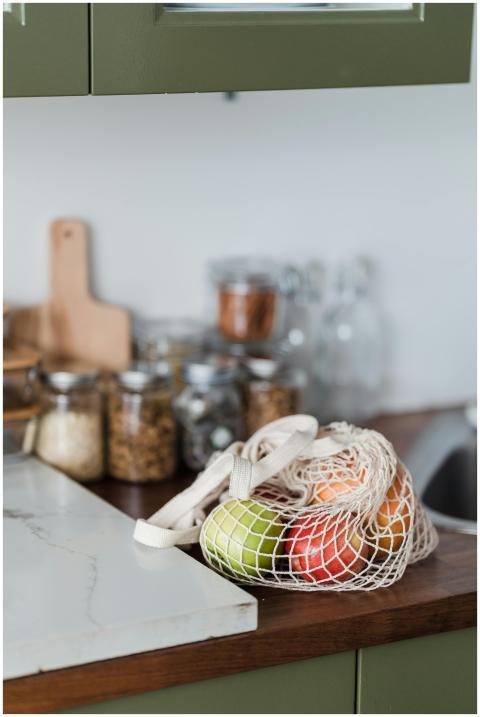 Fresh fruits in a mesh bag on a kitchen counter, p