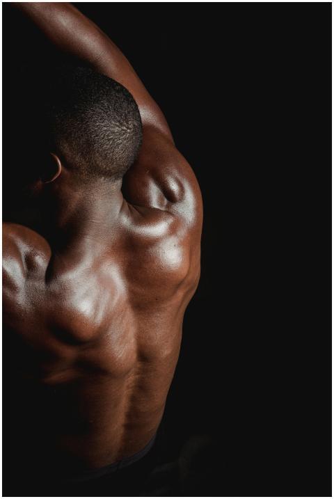 Portrait of a shirtless man flexing his muscular b