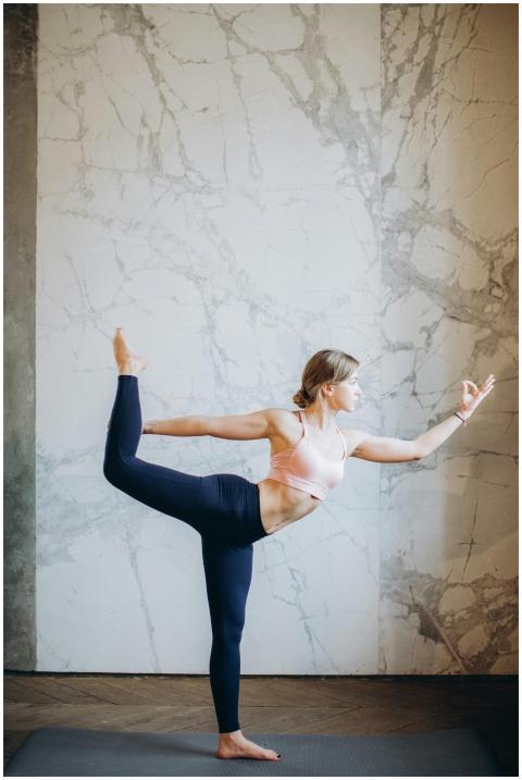 A woman performing a yoga pose indoors, showcasing