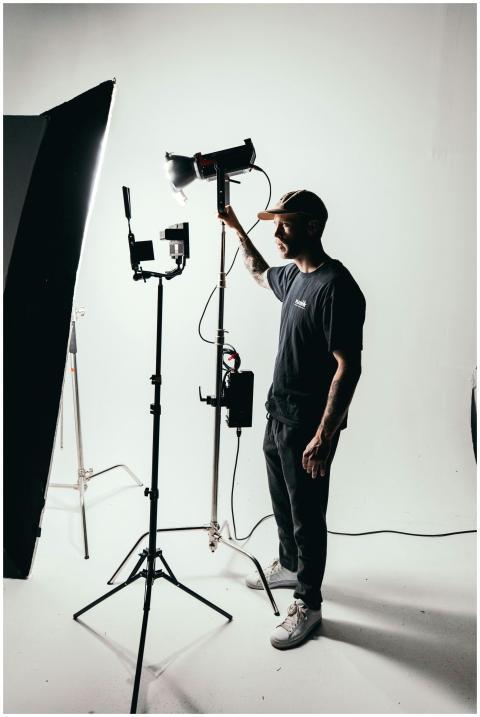 Photographer adjusting studio lights on set with p
