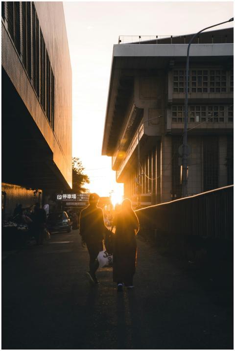 Silhouettes of people walking through city street
