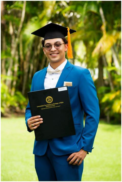Young man in blue suit celebrating graduation outd